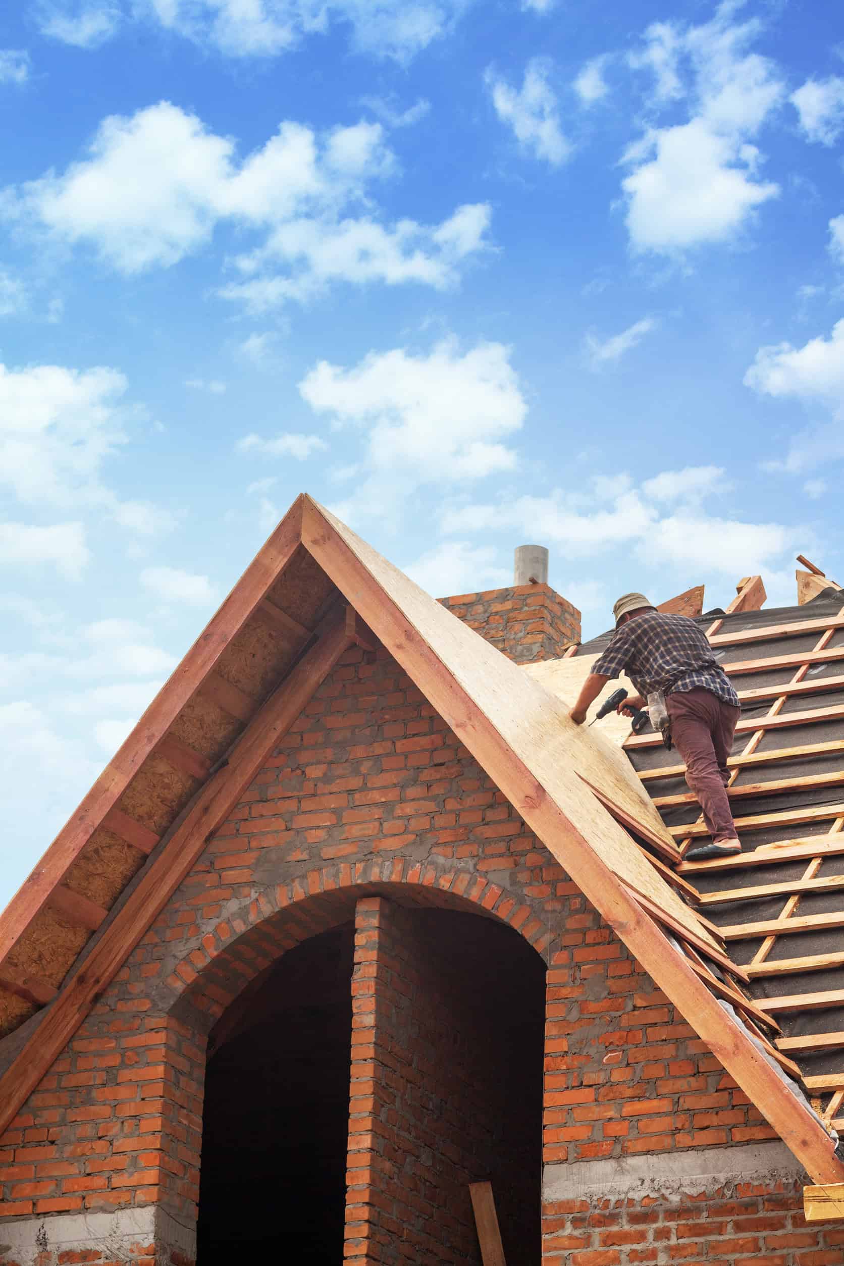 Ouvrier construisant le toit en briques d'une maison.