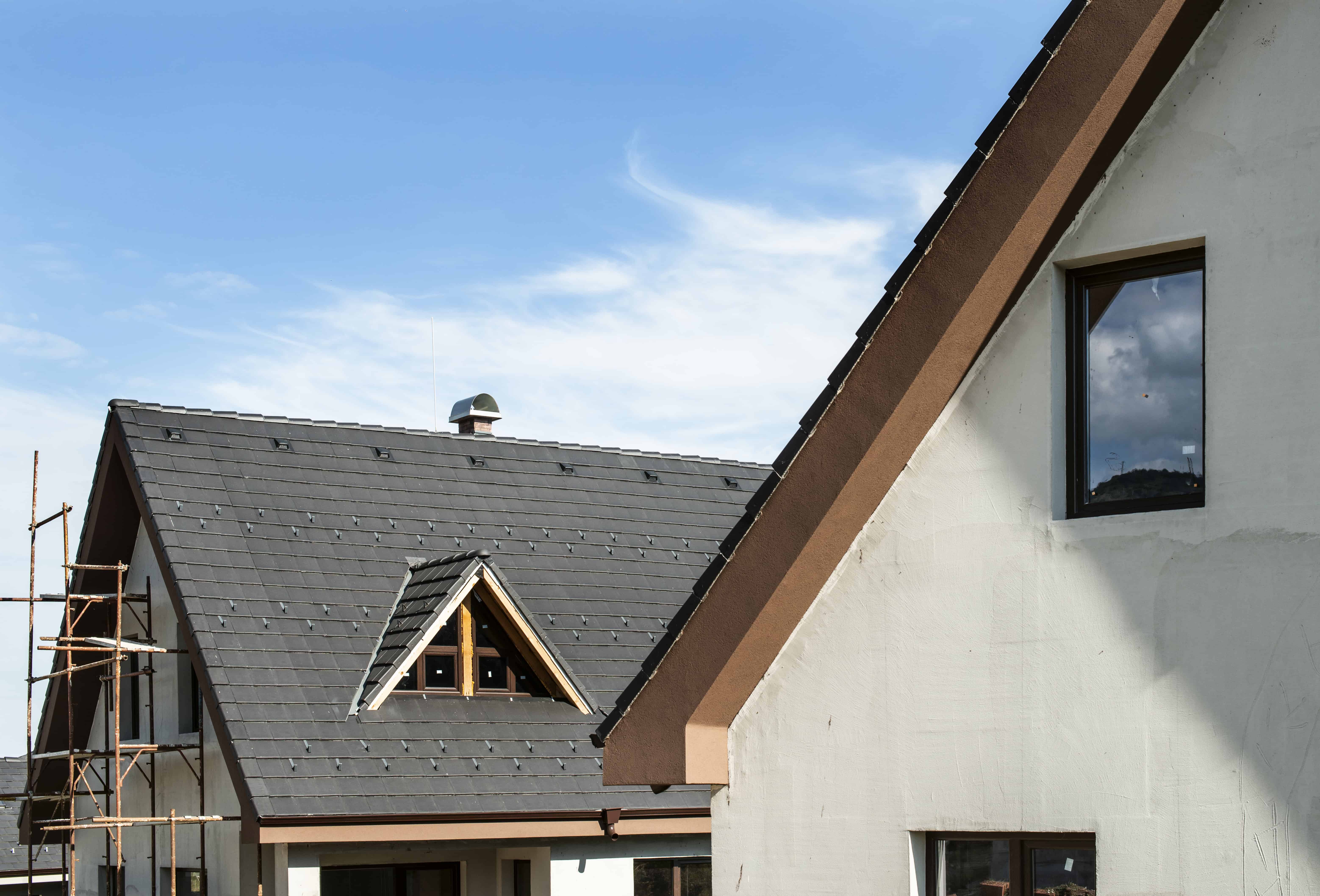 Toit moderne avec fenêtre et ciel bleu.