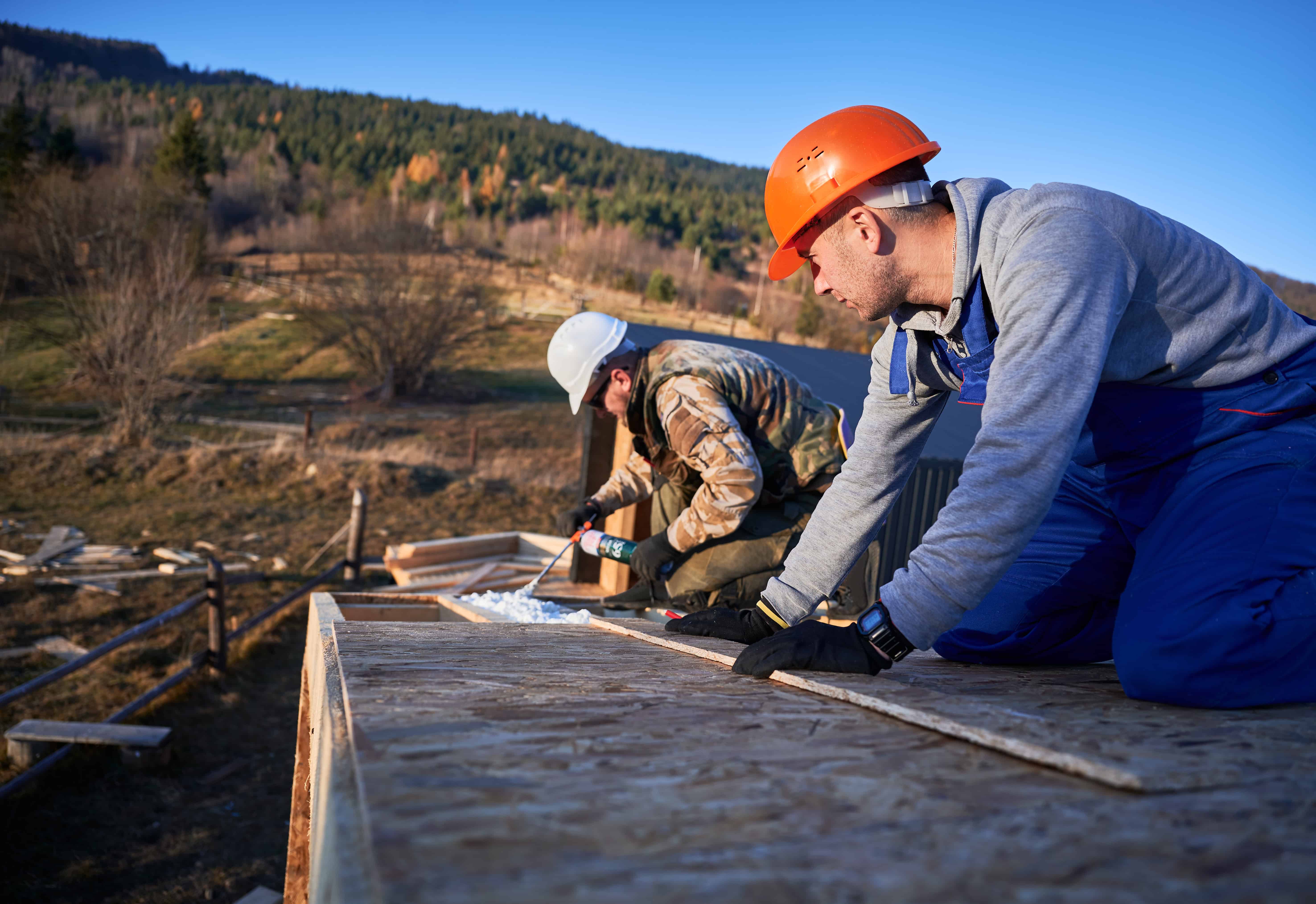 Travailleurs construisant un toit en plein air.